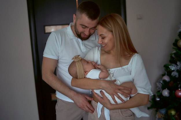 Los padres sostienen a un bebé en casa.