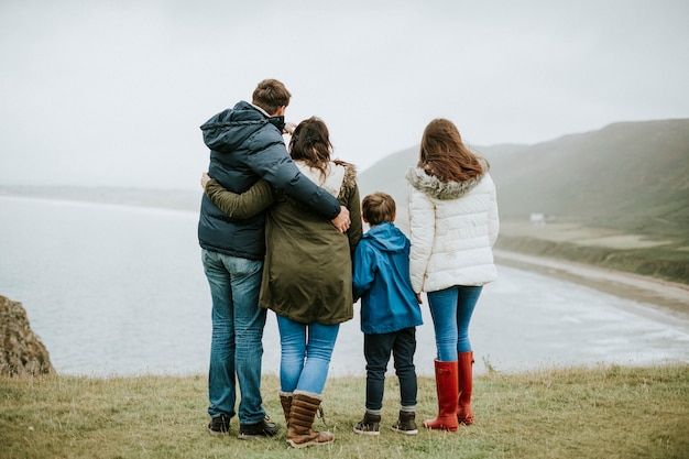 Foto padres con sus hijos mirando al mar