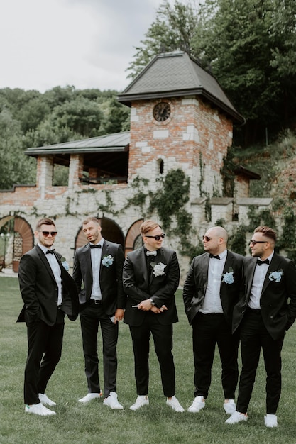 Foto padrinhos e noivos bonitos e elegantes posando ao ar livre