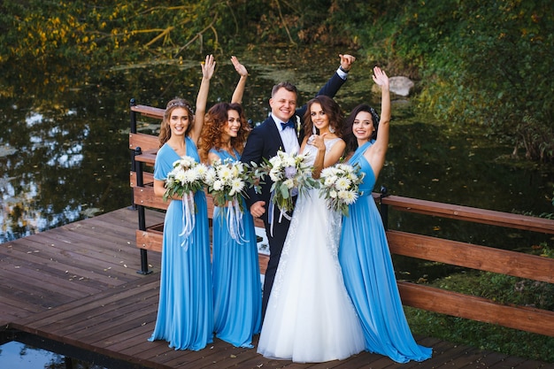 Padrinos de boda y damas de honor con recién casados en la ceremonia de la boda