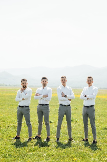 Padrinos de boda y novio posando al aire libre el día de la boda.