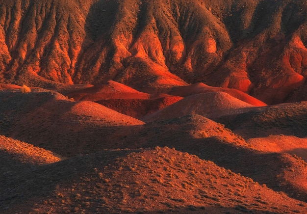 Foto padrões abstratos de montanhas de areia e deserto em cor de tijolo ao pôr do sol