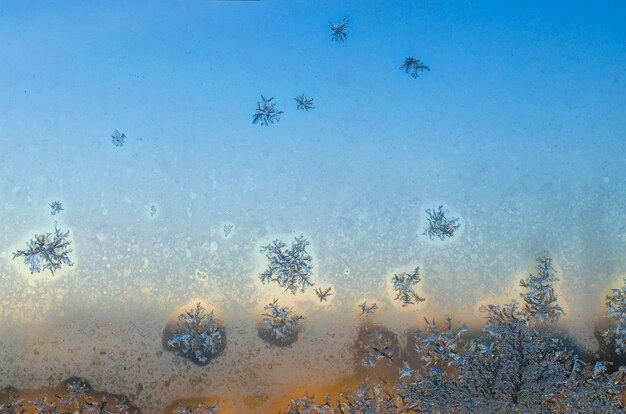 Padrões congelados de gelo na janela no inverno