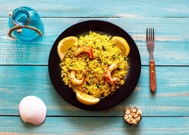 Paella con camarones en un fondo de madera azul