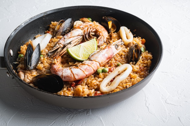 Paella com frutos do mar e frango no fundo branco