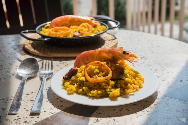 Paella de comida típica española en el fondo de granito