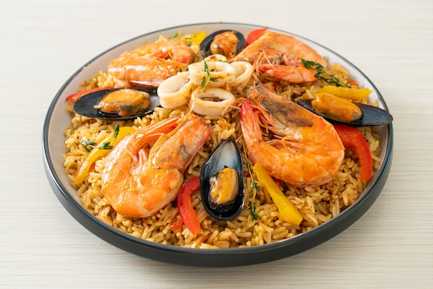 Paella de frutos do mar com camarões, amêijoas, mexilhões com arroz de açafrão - comida espanhola