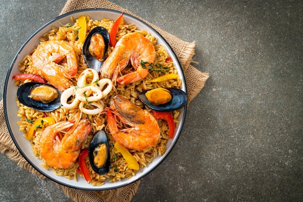 Foto paella de frutos do mar com camarões, mariscos, mexilhões em arroz de açafrão - estilo de comida espanhola