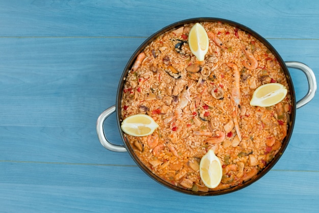 Paella de frutos do mar em um fundo azul de madeira