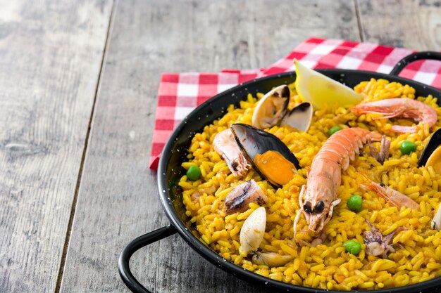 Paella de frutos do mar espanhol tradicional na mesa de madeira