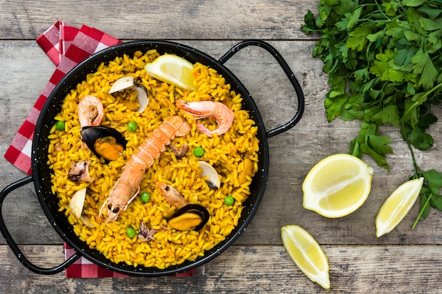 Paella de frutos do mar espanhol tradicional na vista superior de madeira