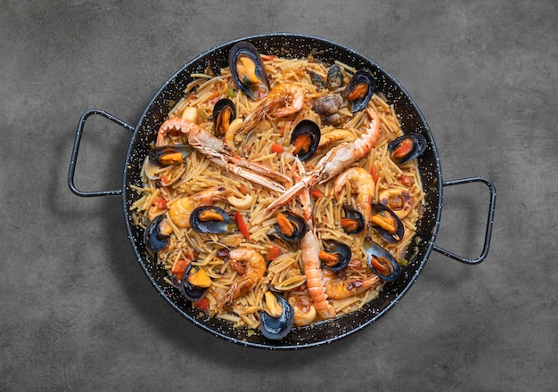 Paella de massas de frutos do mar, culinária espanhola em mesa rústica