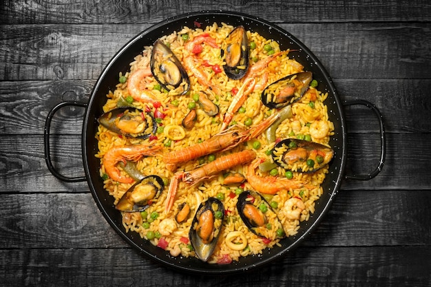 Paella espanhola em uma mesa de madeira