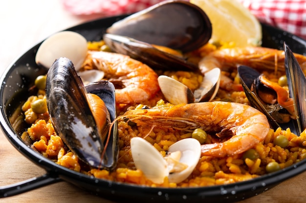 Paella espanhola tradicional de frutos do mar em mesa de madeira