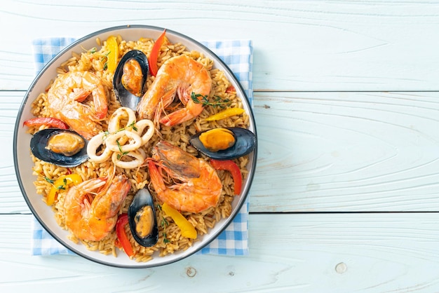 Paella marinera con gambas almejas mejillones sobre arroz azafranado