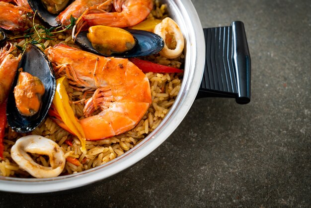 Paella de marisco con gambas, almejas, mejillones sobre arroz con azafrán - estilo de comida española