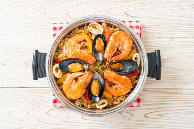 Paella de marisco con gambas, almejas, mejillones sobre arroz con azafrán - estilo de comida española