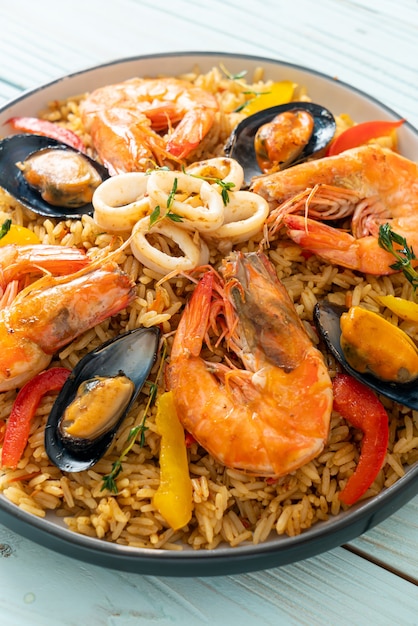 Paella de marisco con gambas, almejas, mejillones sobre arroz con azafrán - estilo de comida española