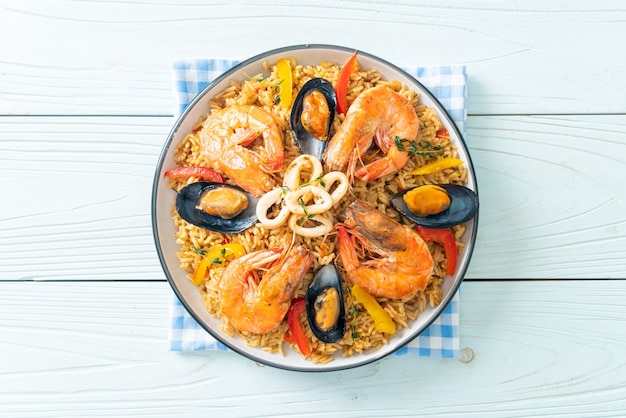 Paella de marisco con gambas, almejas, mejillones sobre arroz con azafrán - estilo de comida española
