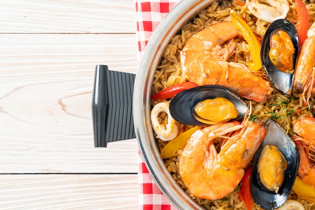 Paella de marisco con gambas, almejas, mejillones sobre arroz con azafrán - estilo de comida española