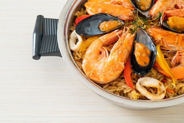 Paella de marisco con gambas, almejas, mejillones sobre arroz con azafrán - estilo de comida española