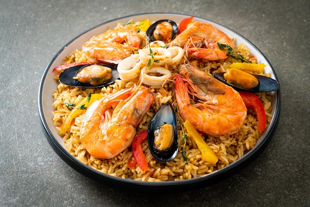 Paella de mariscos con camarones almejas en arroz azafrán