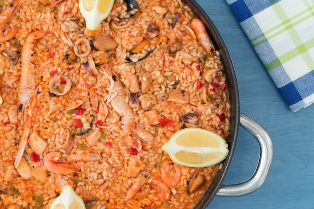 Paella de mariscos en un fondo azul de madera