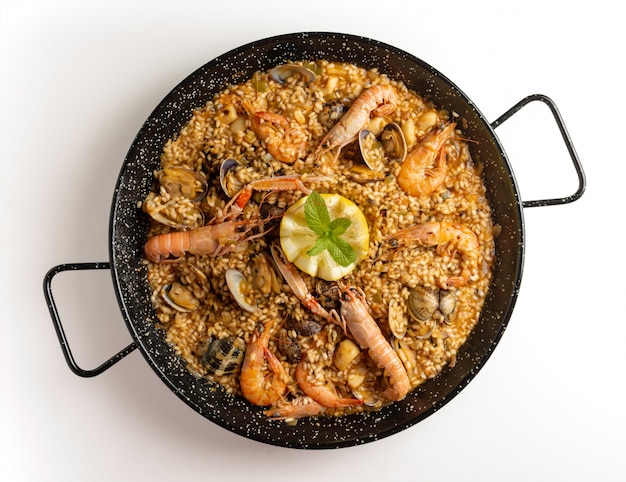 Paella de mariscos sobre fondo blanco.