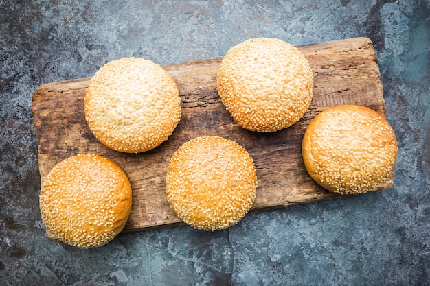 Pães de hambúrguer caseiro fresco em uma tábua sobre pedra