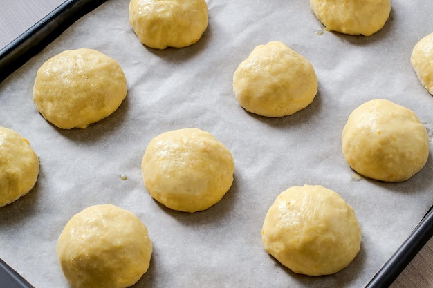 Pães de massa de fermento na assadeira antes de assar