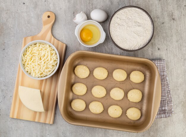 Pães de queijo típico brasileiro crus com ingredientes.