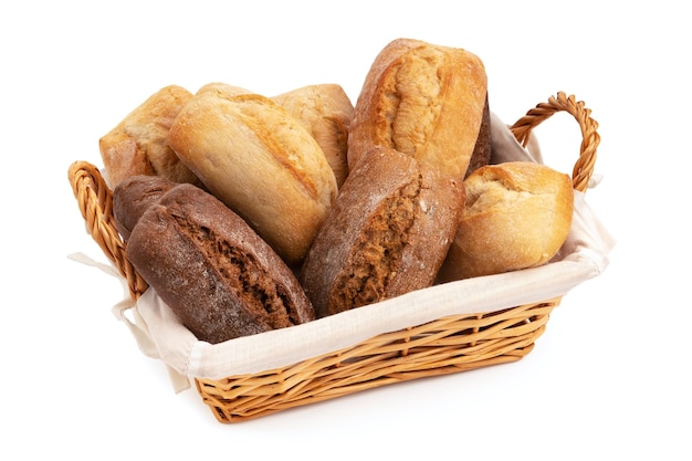 Pães de trigo e centeio frescos em uma cesta de vime isolada em branco