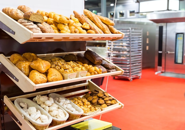 Pães e pãezinhos frescos nas prateleiras da cozinha da padaria