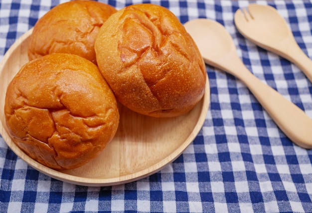 Pães em placa de madeira com colher e garfo