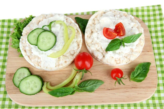 Pães estaladiços saborosos com legumes isolados no branco