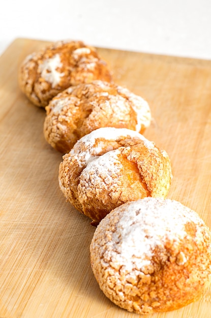 Pães feitos em casa frescos com creme de creme e açúcar em pó