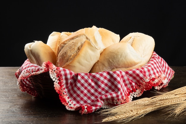 Pães franceses na cesta com mesa preta.