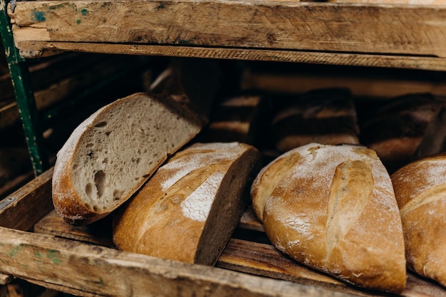 Pães frescos apenas assados em um carrinho de madeira carrinho de madeira com pão para assar acabado de sair do forno muitos pães brancos