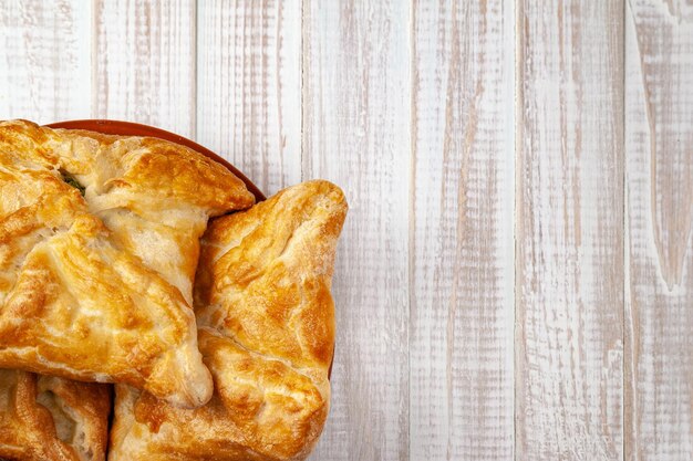 Pães frescos com recheio de legumes pão de trigo com recheio de legumes em um fundo branco de madeira