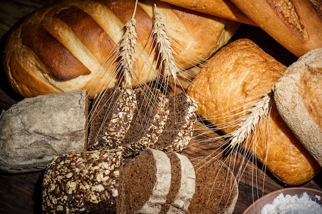 Pães frescos com trigo e glúten em uma mesa de madeira