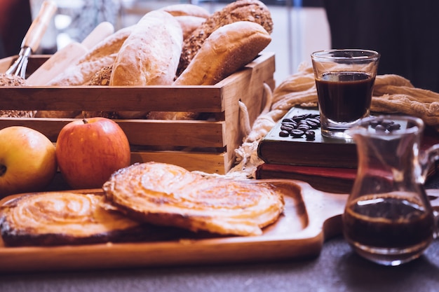 Pães, maçãs e café cozidos em uma tabela.