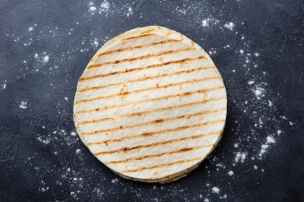 Pães planos de tortilhas grelhadas em fundo cinza escuro Copiar espaço Vista superior