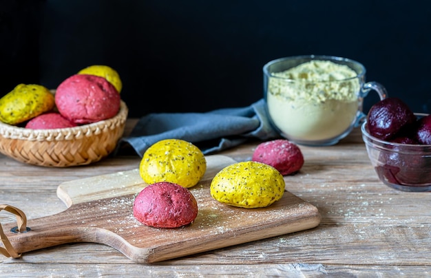 Pãezinhos amarelos e rosa caseiros frescos feitos com sementes de farinha integral e corantes alimentares naturais como beterraba vermelha e açafrão