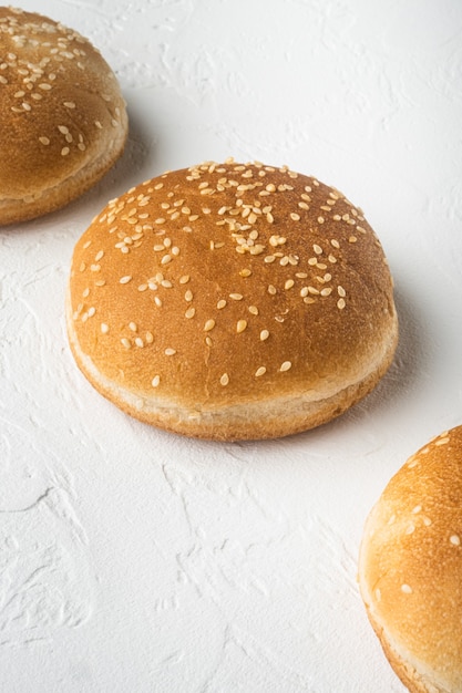 Pãezinhos de hambúrguer com gergelim, mesa de pedra branca