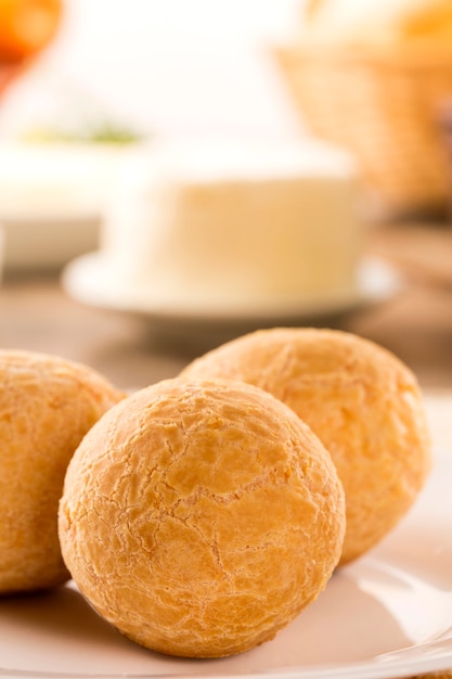 Foto pãezinhos de queijo brasileiro. mesa café da manhã com frutas e pão de queijo.