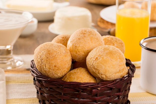 Foto pãezinhos de queijo brasileiro. mesa café da manhã com frutas e pão de queijo.