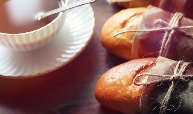 Pãezinhos frescos para o café da manhã. bun com manteiga para uma xícara de café da manhã. café da manhã no hotel pães chá de geléia e um buquê de flores.