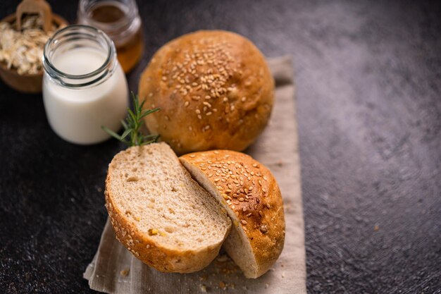 Pãezinhos integrais caseiros com sementes de gergelim em fundo rústico Pão artesanal saudável