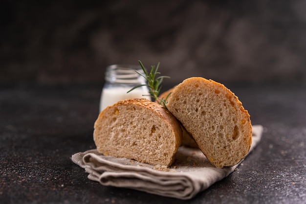 Pãezinhos integrais caseiros com sementes de gergelim em fundo rústico Pão artesanal saudável