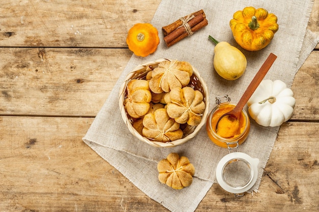 Pãezinhos ou biscoitos de abóbora, assados tradicionais de outono. Comida caseira sazonal e decoração de outono. Fundo de tábuas de madeira antigas, vista superior